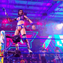 a female wrestler in a wrestling ring with the word w live on the bottom