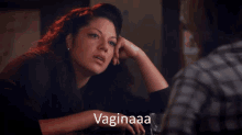 a woman sits at a table with the word vaginaaa written on the bottom