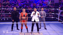 a group of people standing in a wrestling ring with the words one word familia on the bottom