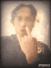 a man is making a middle finger gesture in front of a shotout logo