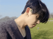 a person with a flower in their hair wearing earrings