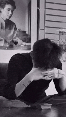 a man sits at a table with his head in his hands