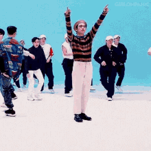 a man in a striped sweater is dancing in front of a crowd .