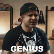 a man wearing a tuxedo t-shirt and a hat says genius