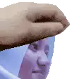 a close up of a person 's head with a hand on it .