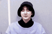 a young man wearing a bucket hat and a purple shirt