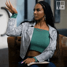 a woman sitting on a couch with her hand in the air