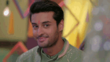 a man with a red circle on his forehead smiles for the camera