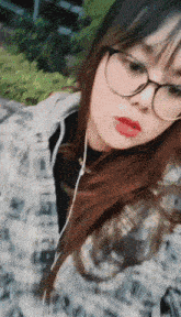 a girl wearing glasses and red lipstick takes a picture of herself