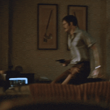 a man is standing in a dark room looking out of a window