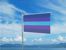 a blue and purple flag is flying in front of a blue sky