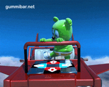 a gummy bear is dancing on a dance floor in a red car