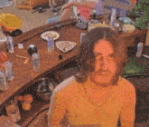 a man in a tank top is standing in front of a messy bar with a box that says ' coca cola '