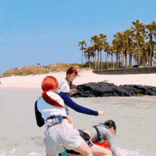 a woman with red hair is standing in the water near a palm tree