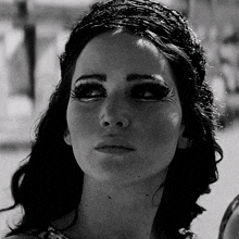 a black and white photo of a woman 's face with long eyelashes