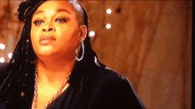 a close up of a woman wearing hoop earrings and a black top