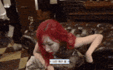 a woman with red hair sits on a leather couch with a sticker that says ' a ' on it