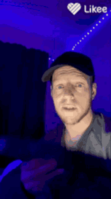 a man with blue eyes is taking a selfie with a likee heart in the corner