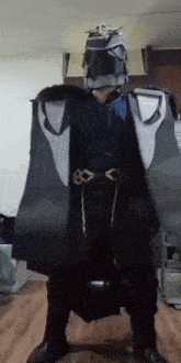 a man in a costume is standing on a wooden floor in a room