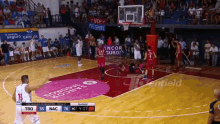 a basketball game is being played on a court with an anchor seguros logo on the floor