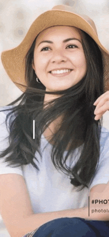 a woman wearing a straw hat is smiling and looking at the camera
