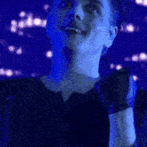 a close up of a man 's face with a blue light behind him .