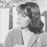 a black and white photo of a woman with a flower in her hair