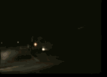 a truck is driving down a road at night with a lot of lights on .
