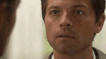 a close up of a man 's face looking at another man