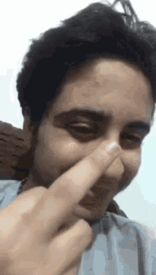 a man is covering his nose with his finger .