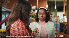 two women are standing next to each other with a nbc logo on the bottom right