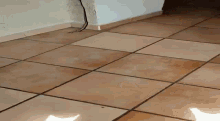 a person is standing next to a toilet in a bathroom with tile floors .
