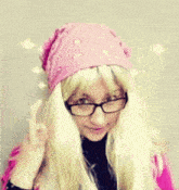 a woman with blonde hair wearing glasses and a pink bandana