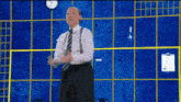 a man and woman are dancing in front of a blue wall