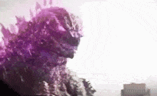 a purple godzilla is standing in front of a white building .