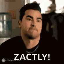 a man from schitt 's creek is making a face and says zachly