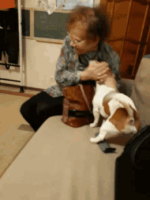 a woman sitting on a couch with a dog