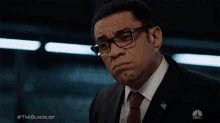 a man wearing glasses and a suit has the hashtag #theblacklist