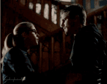 a man and a woman are looking into each other 's eyes in a dark room