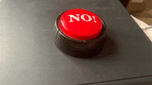 a red no button is on a black surface