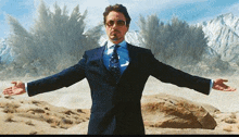 a man in a suit and tie is standing with his arms outstretched in front of a mountain .