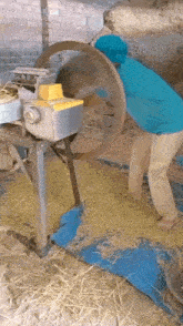 a man is working on a machine that is cutting hay