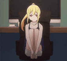 a girl is sitting on a chair in front of a computer