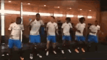 a group of soccer players are dancing in front of a mirror .