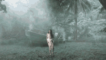 a woman in a white dress stands in front of a boat in the woods