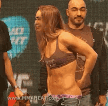 a woman in a bikini is standing next to a man in a shirt .