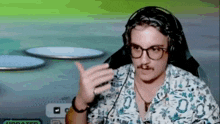 a man with glasses and a mustache is wearing headphones and a shirt .