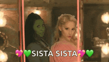 two women are standing next to each other on a swing with the words `` sista sista '' written on it .