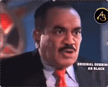 a man with a mustache is wearing a suit and tie and is talking to someone