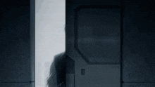 a man in a suit stands in a doorway with his eyes closed